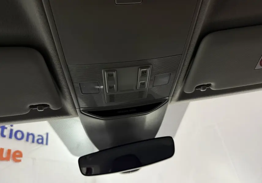 Vue intérieure centrée sur le plafonnier et le rétroviseur intérieur d'une Skoda Kamiq rouge 2024.