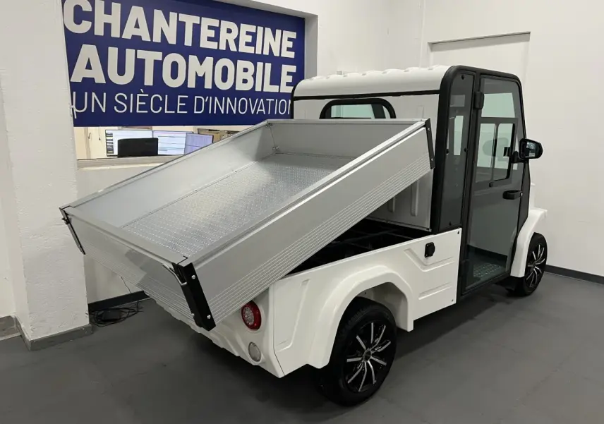 Vue 3/4 arrière droite du pick-up électrique blanc Liberty L7E H2 160 avec kit ridelles relevé et jantes alliage 13 pouces.