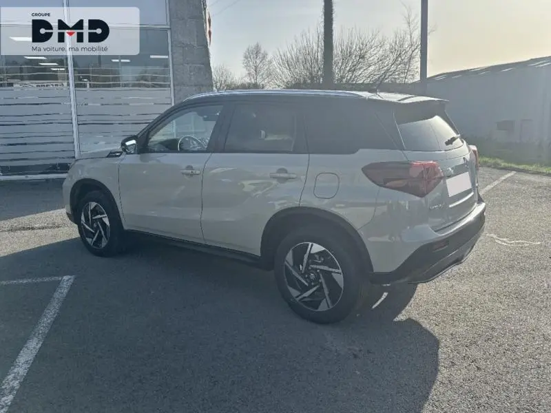 Suzuki Vitara 2026 vue 3/4 arrière côté gauche en So'Color Savanna Ivory/Black métal avec jantes alu distinctives.