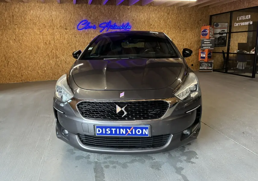 Vue frontale d'une DS5 gris métallisé 2018 avec calandre distinctive et phares LED dans un showroom.