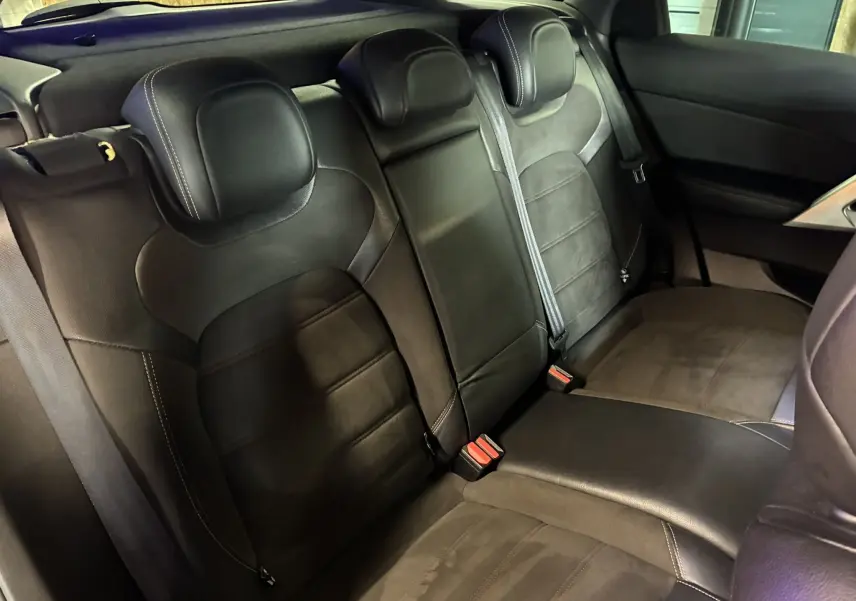 Vue intérieure des sièges arrière en cuir noir de la DS5 2.0 BlueHDi 180, soulignant l’espace et les ceintures de sécurité.