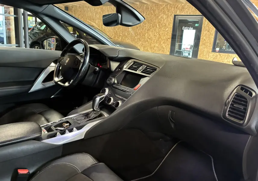Vue intérieure côté conducteur de la DS5 2.0 BlueHDi 180 gris, avec tableau de bord noir et console centrale moderne.