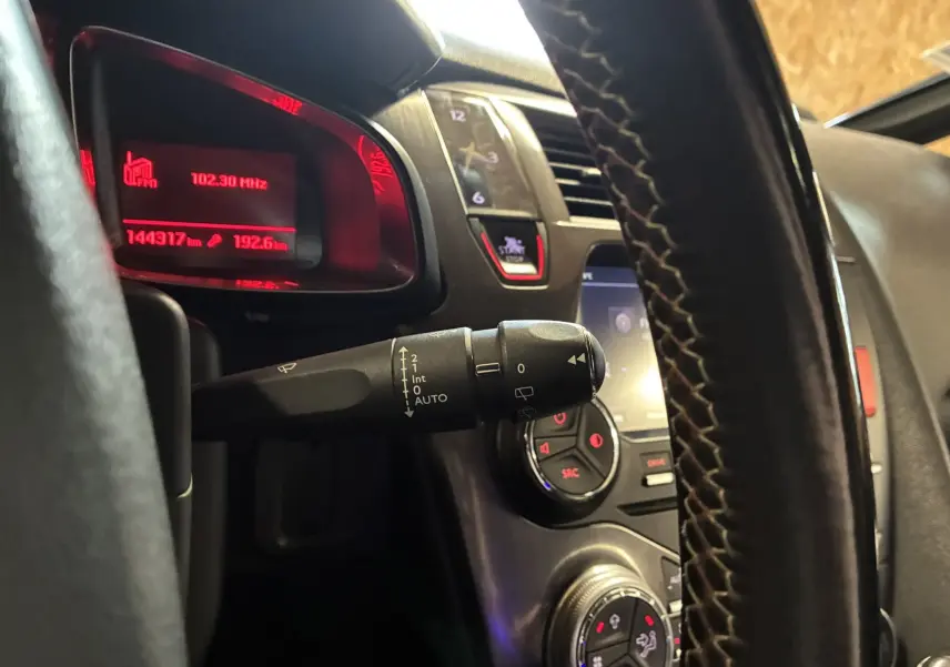 Vue intérieure rapprochée du tableau de bord et volant noir de la DS5 2.0 BlueHDi, avec affichage rouge du compteur.