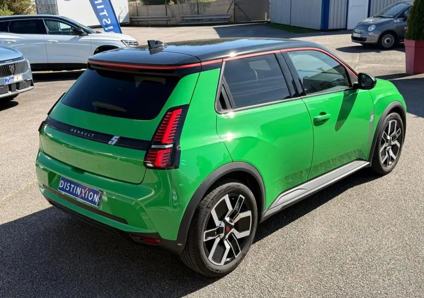 Vue 3/4 arrière droite d’une Renault R5 E-Tech électrique vert Pop avec toit noir étoile et jantes bi-ton.
