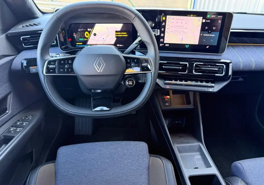 Vue intérieure frontale du tableau de bord et volant Renault R5 E-TECH 100% électrique avec écran tactile et sellerie textile bleue.