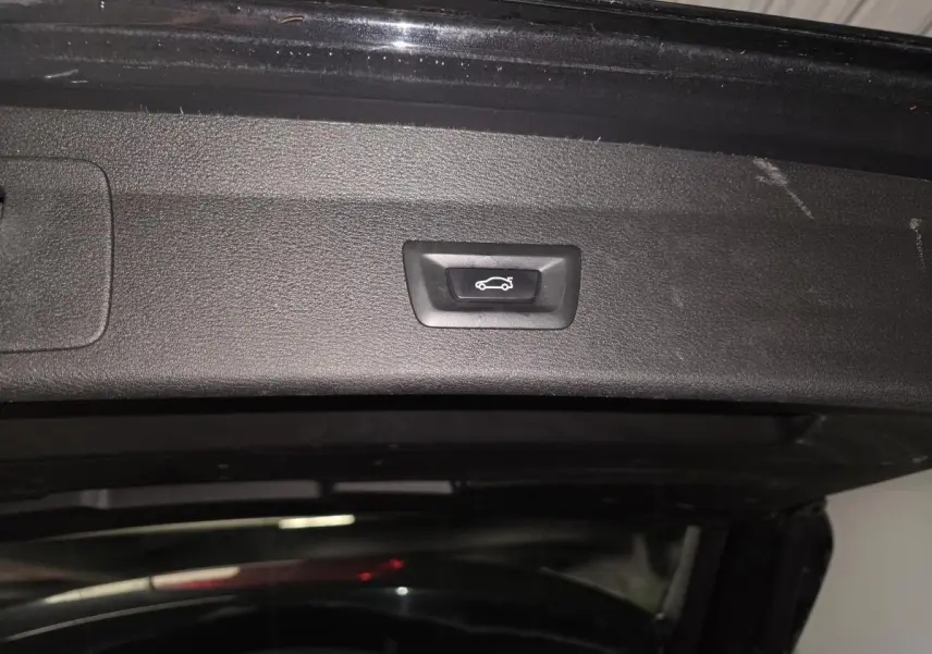 Bouton d'ouverture électrique du hayon sur l'intérieur du coffre d'un BMW X1 noir xDrive 25d F48 xLine 2016.