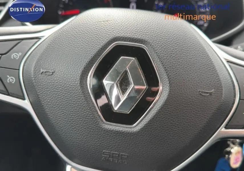 Gros plan sur le volant noir avec logo Renault au centre dans l’habitacle d’une Clio blanche 2021.