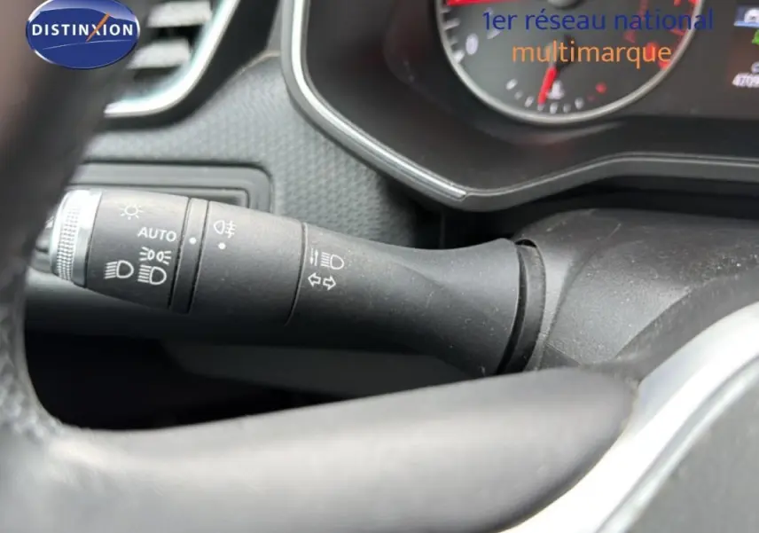 Gros plan sur la commande d’allumage automatique des feux à gauche du volant dans l’habitacle d’une Renault Clio blanche 2021.