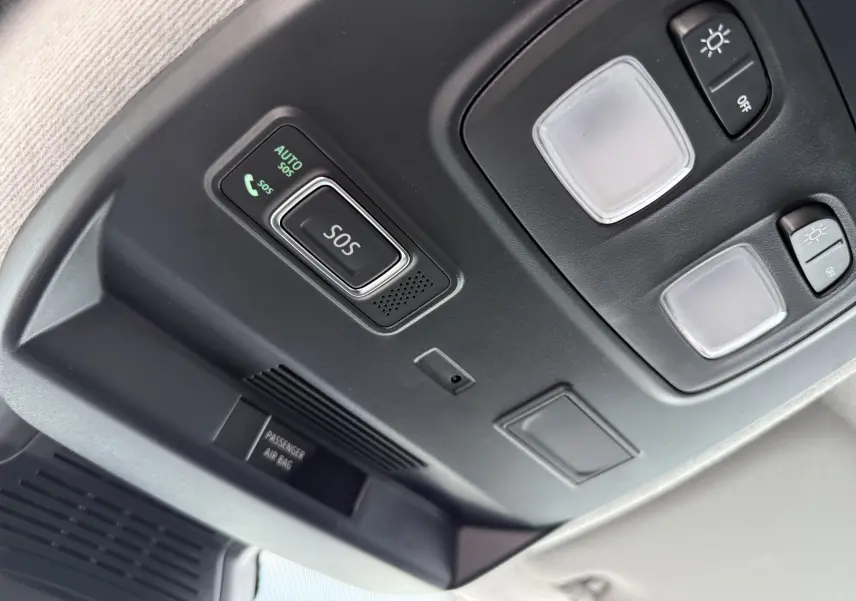 Vue en gros plan du panneau de commande intérieur au plafond du Renault Trafic Fourgon blanc, avec bouton SOS et éclairages intégrés.