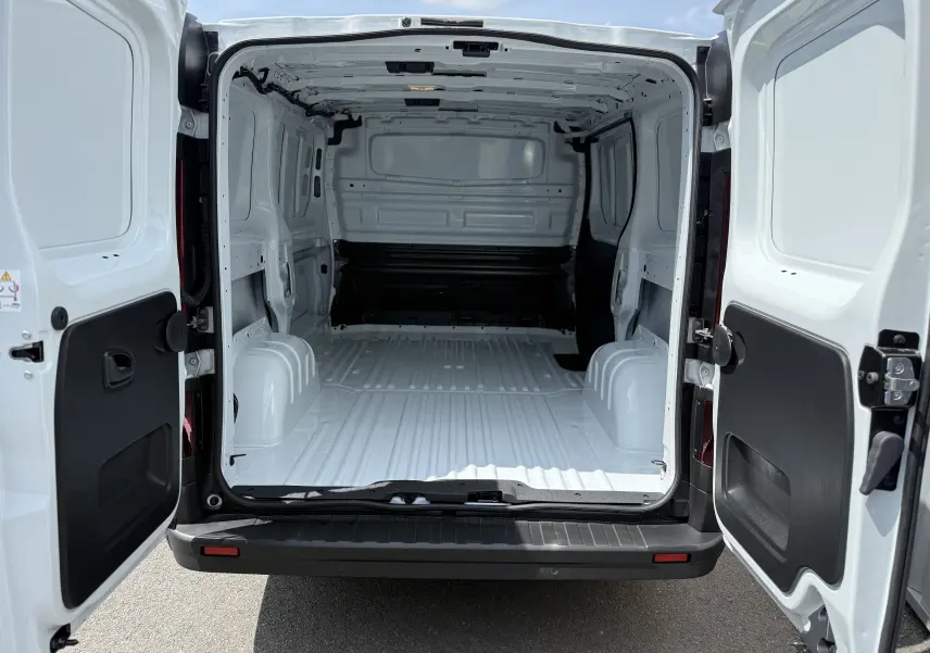 Vue arrière ouverte du Renault Trafic Fourgon blanc 2025, montrant l'espace de chargement vide et la double porte battante.