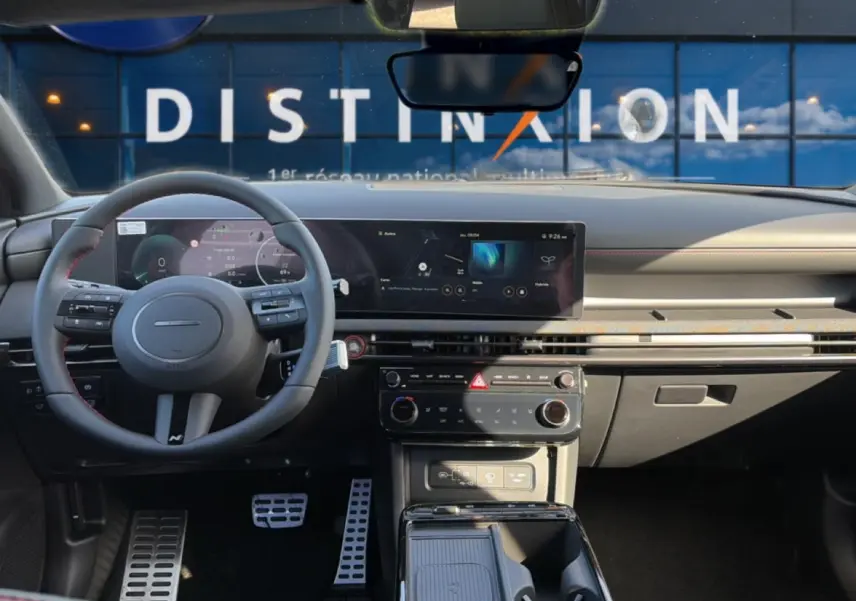Vue intérieure du tableau de bord et volant cuir gris du Hyundai Tucson 2026 avec écran tactile panoramique et pédalier sport.