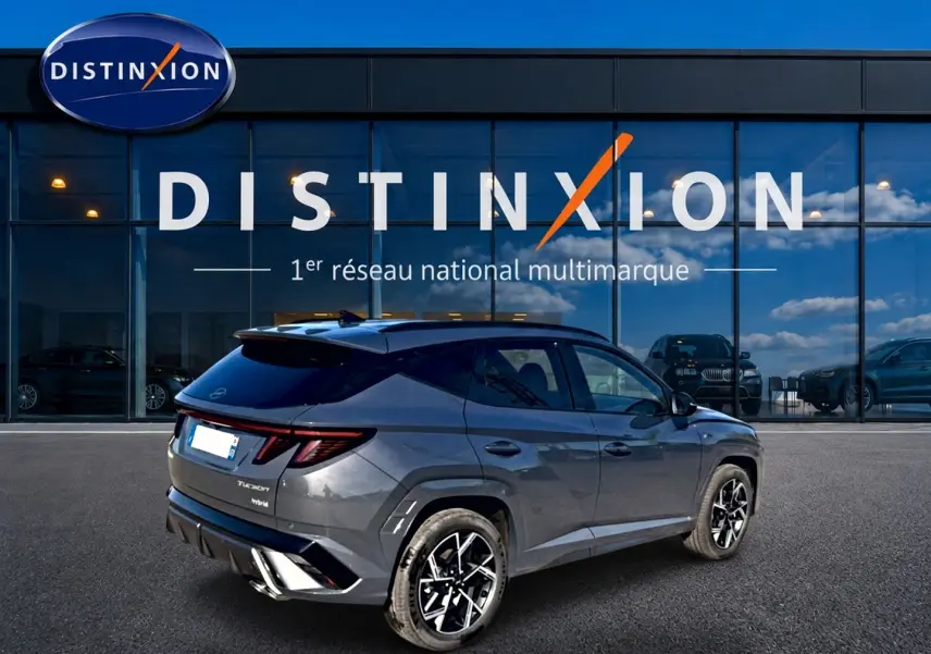 Vue 3/4 arrière droite du Hyundai Tucson 2026 gris ecotronique avec jantes alliage et toit noir contrasté.