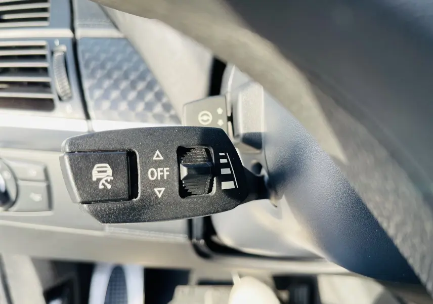 Gros plan sur le levier de réglage du système de contrôle de traction dans l'habitacle d'une BMW X6 blanche de 2013.