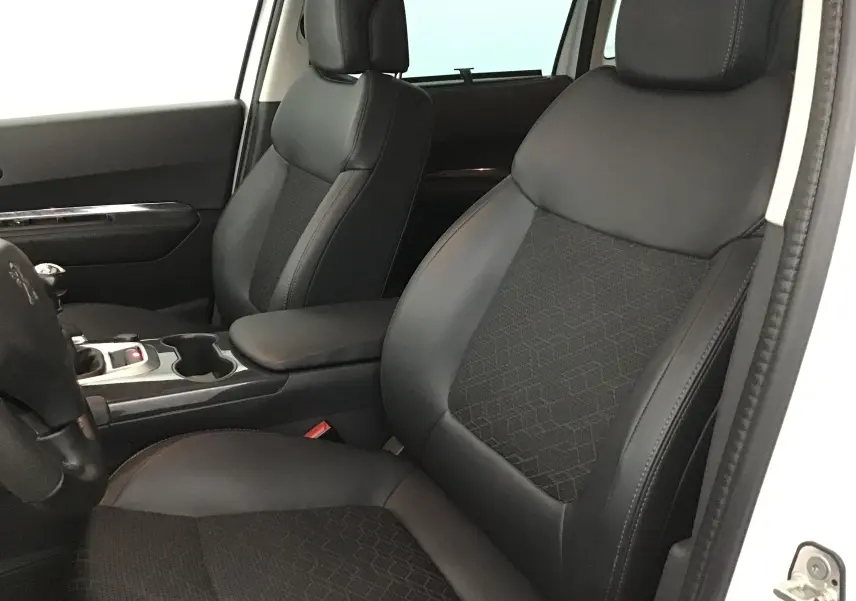 Intérieur du Peugeot 3008 blanc, vue côté avant droit sur les sièges en cuir noir et tissu avec console centrale.