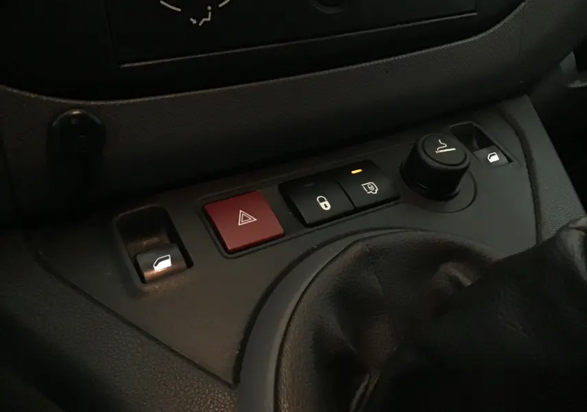 Gros plan sur la console centrale du Citroën Berlingo blanc, montrant les commandes de verrouillage et lève-vitres.