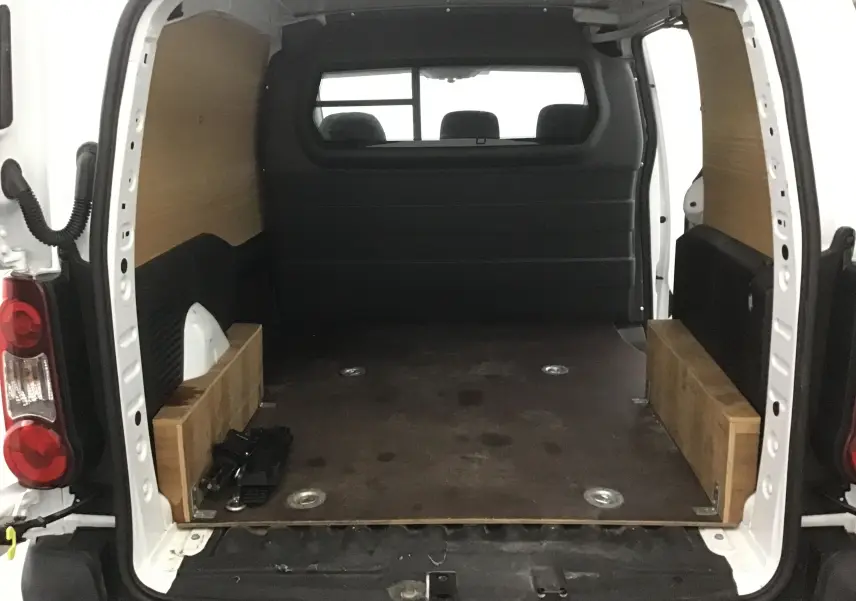 Vue arrière ouverte du Citroën Berlingo blanc 2018 avec espace de chargement boisé et plancher sombre.