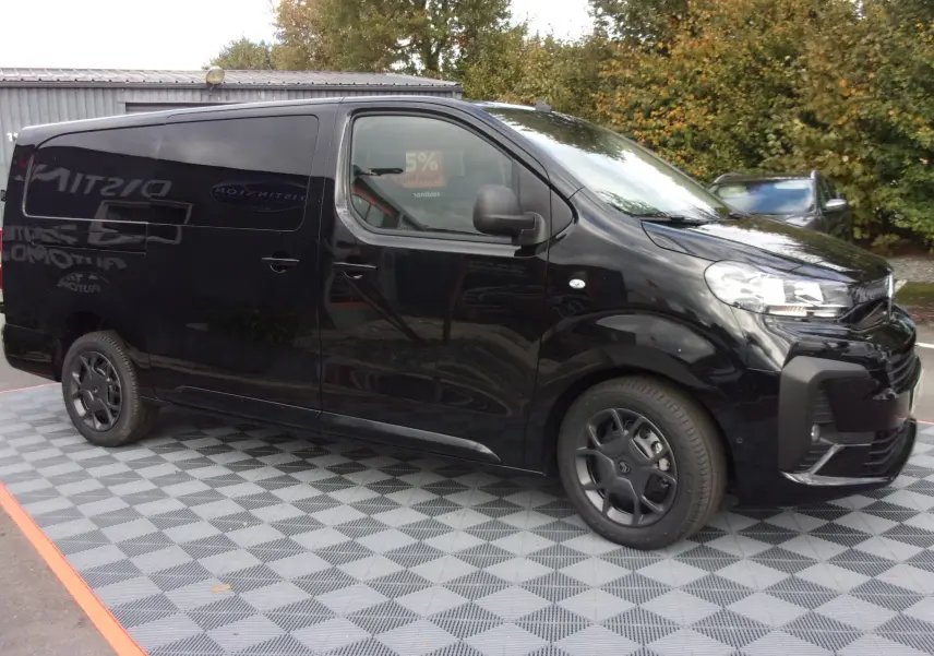 Vue 3/4 avant droit d'un Citroën Jumpy XL noir perla avec jantes noires et porte latérale coulissante.
