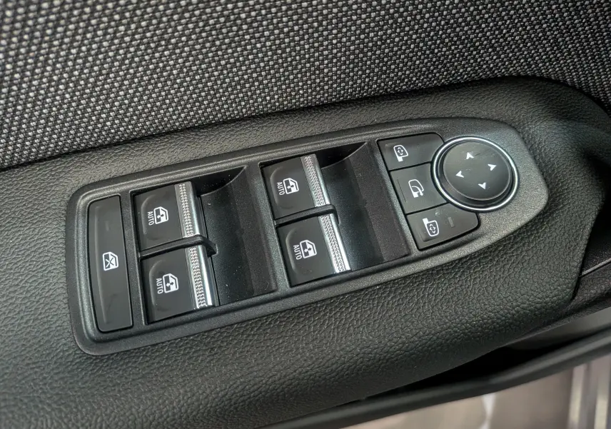 Panneau de commandes des vitres et rétroviseurs sur la porte côté gauche d’une Renault Symbioz gris Cassiopé.