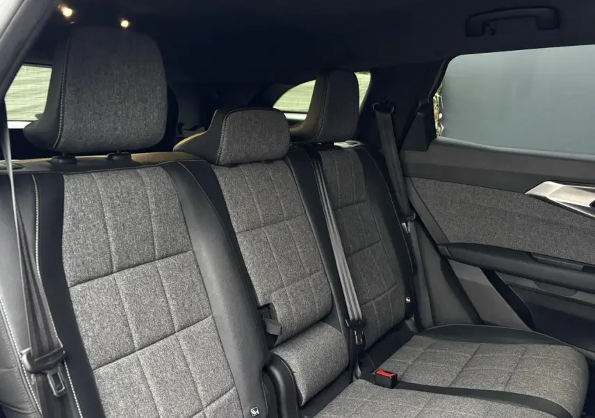 Vue latérale intérieure des sièges arrière en tissu gris et cuir noir du Renault Espace 2024 E-Tech Full Hybrid.