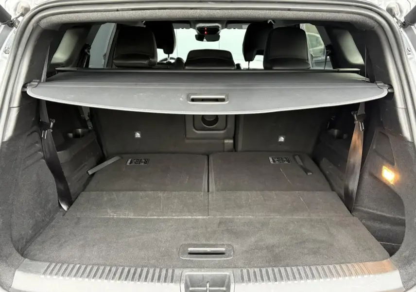 Vue arrière du coffre ouvert du Renault Espace gris schiste, montrant les sièges rabattus et la plage arrière.