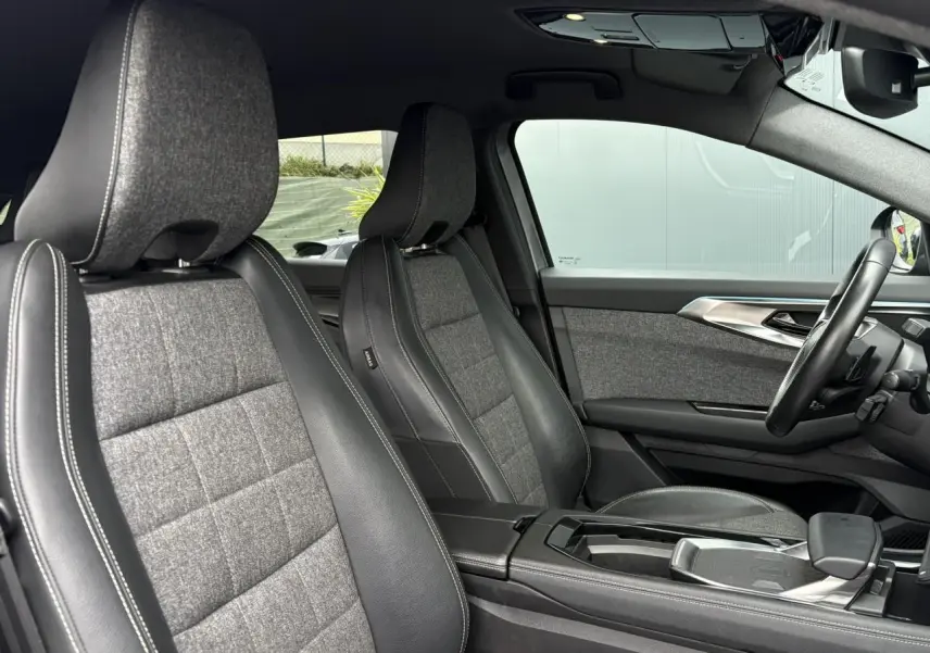 Vue intérieure côté droit du Renault Espace 2024, sièges tissu et cuir gris avec surpiqûres blanches et tableau de bord moderne.