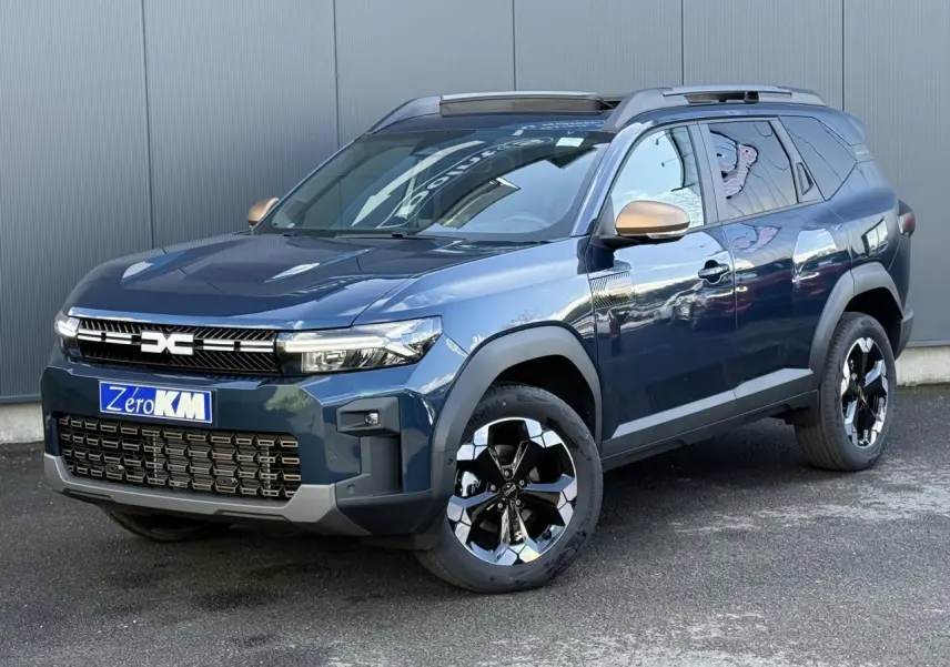 Vue 3/4 avant du Dacia Bigster 2026 bleu indigo avec jantes alliage noires et rétroviseurs bronze.