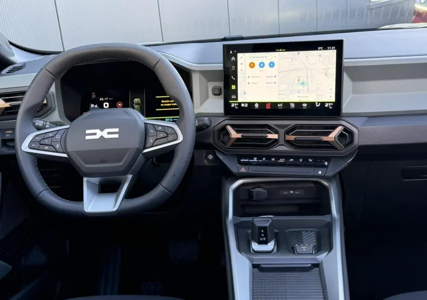 Vue intérieure frontale du tableau de bord du Dacia Bigster 2026 avec écran tactile et volant multifonction noir.