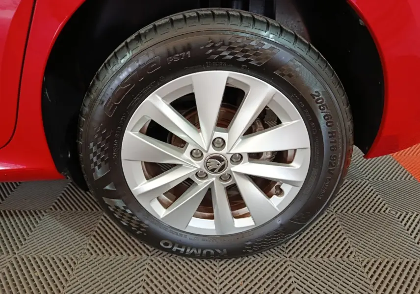 Gros plan sur la roue avant droite argentée d’un Skoda Kamiq rouge, avec jante à 5 doubles branches.