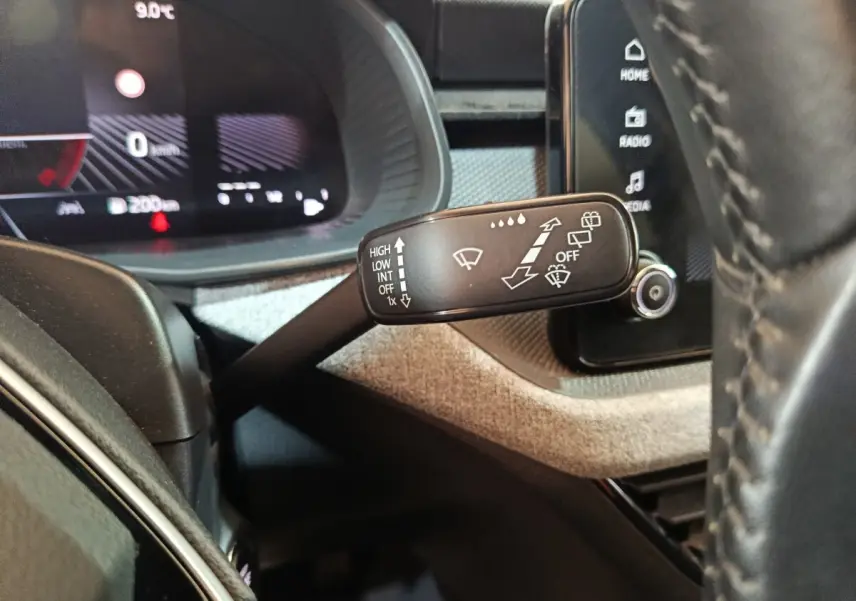 Gros plan sur la manette d’essuie-glace côté gauche du tableau de bord du Skoda Kamiq 2024 rouge avec affichage digital.