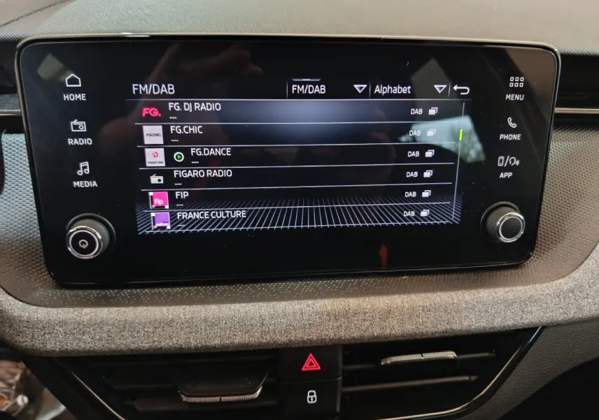 Écran tactile central 8,25 pouces du tableau de bord du Skoda Kamiq 2024, affichant les stations radio FM/DAB.