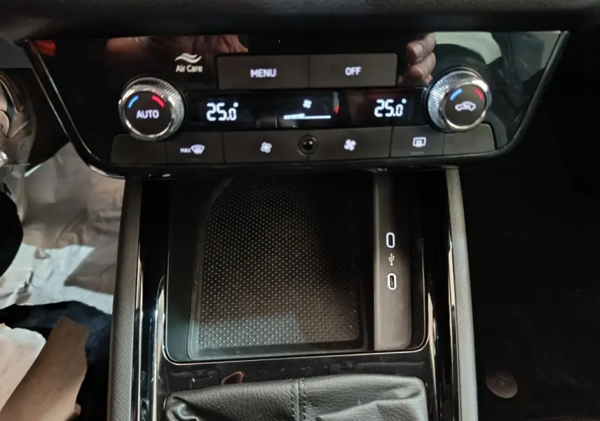 Vue rapprochée de la console centrale noire avec commandes climatisation digitale et ports USB du Skoda Kamiq 2024.