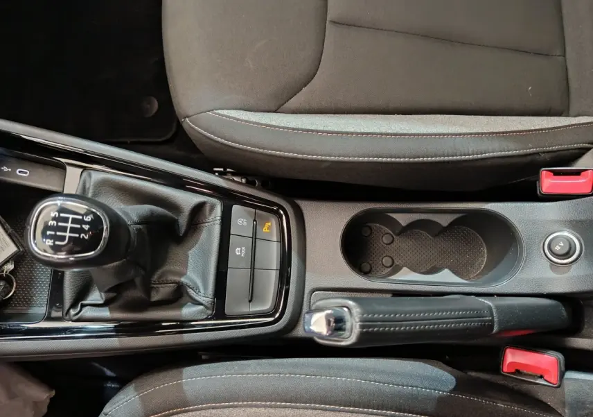 Vue plongeante sur la console centrale noire du Skoda Kamiq 2024 avec levier de vitesse manuel et frein à main cuir.