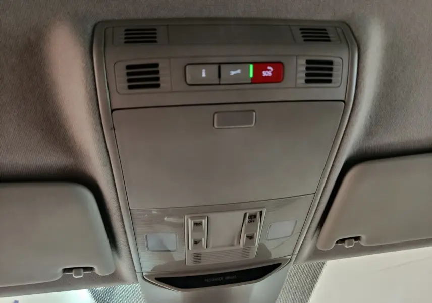 Vue intérieure du plafond d'un Skoda Kamiq rouge 2024, montrant les commandes d'éclairage et le bouton SOS actif.