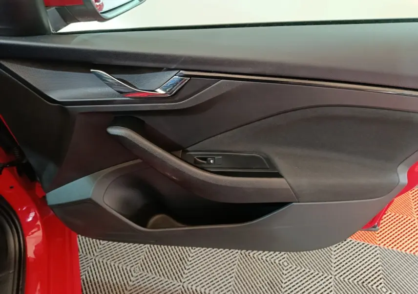 Vue rapprochée de la porte avant gauche noire avec poignée intégrée d’un Skoda Kamiq rouge 2024.