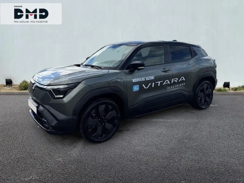 Suzuki Vitara électrique 2026 en 3/4 avant, vert Land Breeze avec toit noir et jantes noires distinctives.
