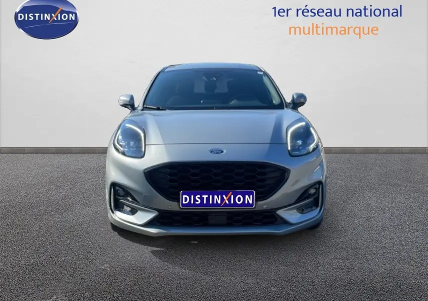 Vue frontale d'une Ford Puma gris Solar Metal 2023 avec calandre noire et phares LED allumés.
