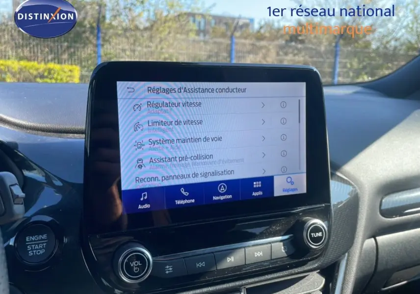 Vue intérieure centrée sur l'écran tactile du tableau de bord d'une Ford Puma 2023, avec commandes d'assistance visibles.