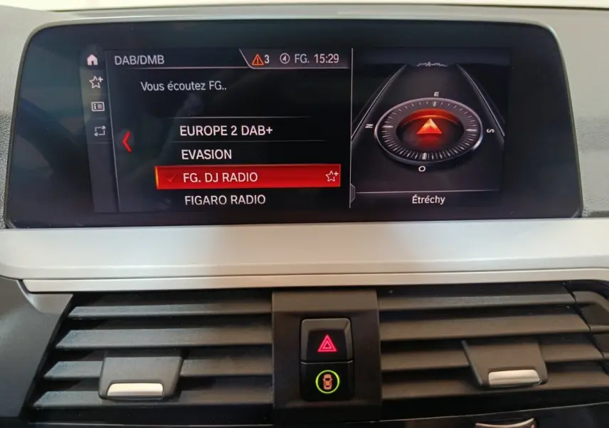 Écran central de navigation et radio du BMW X3 xDrive30e 2020, affichant stations DAB+ et boussole numérique.