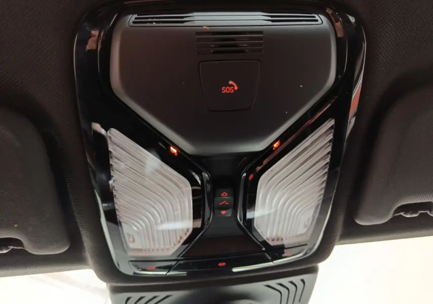 Vue intérieure en plongée du plafonnier noir avec bouton SOS rouge du BMW X3 xDrive30e gris foncé 2020.