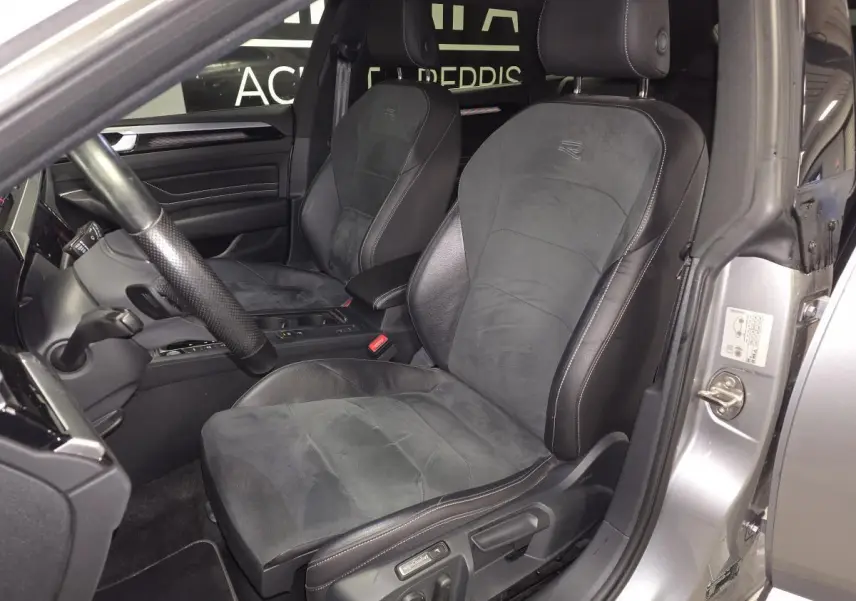 Vue intérieure côté conducteur du Volkswagen Arteon gris 2022, sièges sport en cuir et microfibre avec logo R brodé.