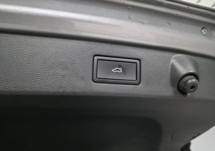 Bouton de déverrouillage électrique du hayon sur le coffre intérieur d’un Volkswagen Arteon gris Shooting Brake 2022.