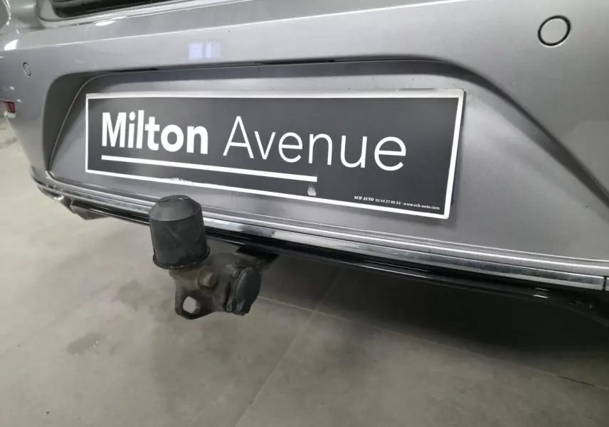 Gros plan sur l'attelage rabattable électrique à l'arrière d'une Volkswagen Arteon gris métallisé.