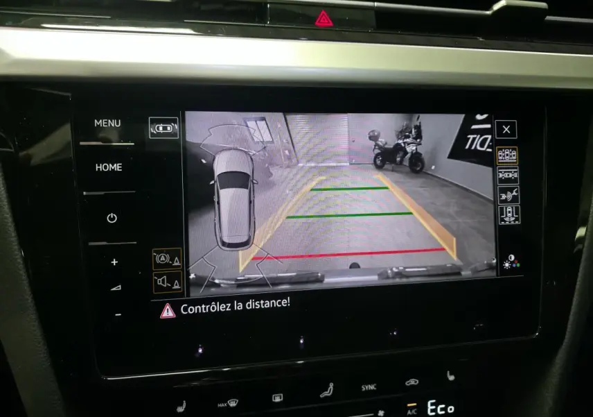 Écran intérieur affichant la caméra de recul et l'aide au stationnement du Volkswagen Arteon gris, vue de face.