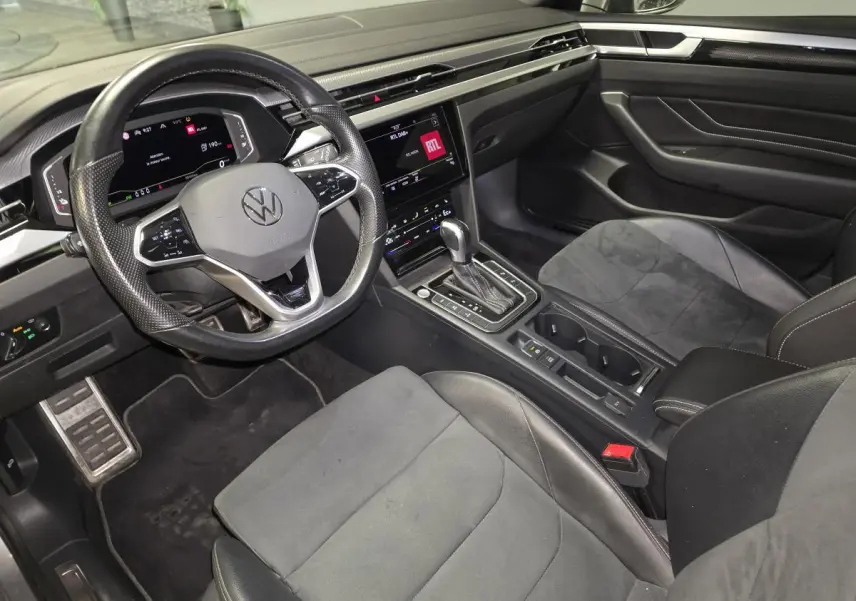Vue intérieure côté conducteur du Volkswagen Arteon Shooting Brake gris, avec volant multifonction, écran tactile et sellerie mixte cuir/alcantara.