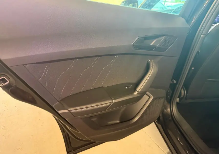 Vue intérieure du panneau de porte arrière gauche noir avec surpiqûres blanches sur un CUPRA Formentor 2025.