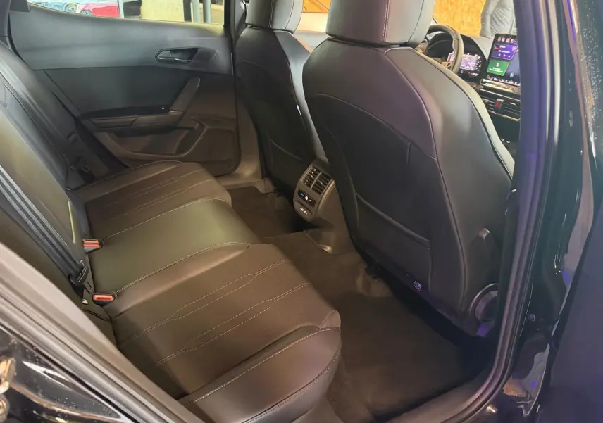 Vue intérieure arrière droite du CUPRA Formentor noir 2025, sièges cuir noirs et console centrale avec commandes climatisation.