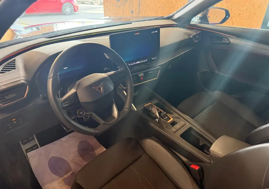 Intérieur noir du CUPRA Formentor 2025, vue côté conducteur, avec écran tactile central et volant cuir.
