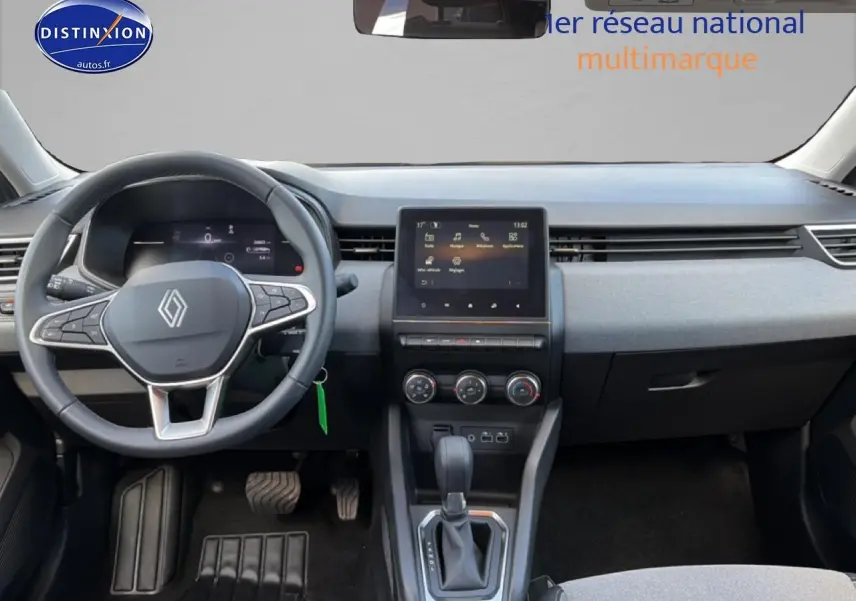 Vue intérieure avant de la Renault Clio V gris métal, avec tableau de bord moderne et écran tactile central.