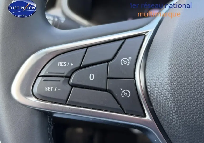 Gros plan sur les commandes de régulateur de vitesse au volant d’une Renault Clio V gris métal, intérieur noir.
