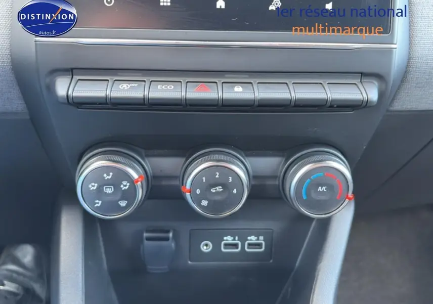 Vue rapprochée des commandes de climatisation et des ports USB du tableau de bord de la Renault Clio V gris métal 2025.